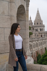 Beautiful young tourist woman posing with gaze to the side at the famous Fisherman's Bastion in Budapest