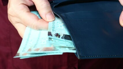 The woman comes out of the wallet and counts Brazilian money Reais, financially economic concept, a file of banknotes of 100 real
 - Powered by Adobe