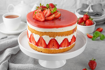Fraisier mousse cake. Strawberry cake with sponge cake, mousse and jelly on a gray concrete background. Summer dessert. Selective focus. Copy space
