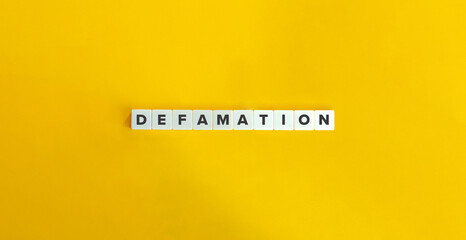 Defamation Word on Letter Tiles on Yellow Background.  - obrazy, fototapety, plakaty