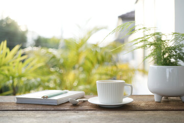 White coffee cup and diary notebooks and plant pot chill outdoor drinking