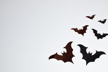 halloween and decoration concept - black paper bats flying over yellow background with space for...