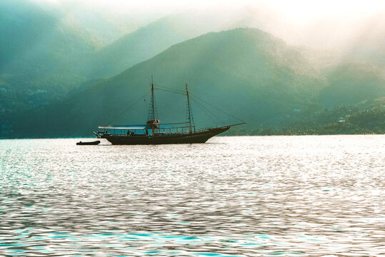Barco escuna ancorado durante o nascer do sol em Ilhabela