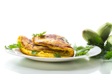 Fried omelette with zucchini,in a plate on a white background.