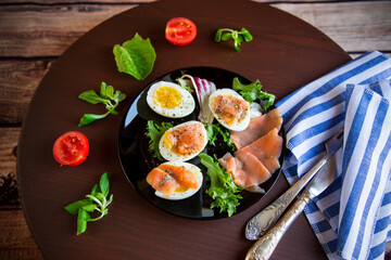 boiled eggs with salted red fish, herbs and seasonings in a plate .