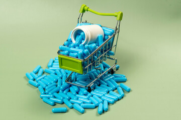 blue medicine capsule in miniature shopping cart