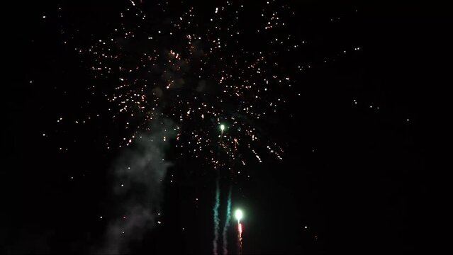 The colorful fireworks lights in the night sky, Spectacular holiday background video from a wedding and Christmas party with explosions, flares, sparks, blurry and clear outlines,selective focus close