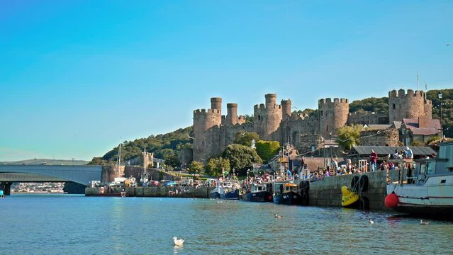 Panoramic view of Conwy Castle in Conwy, North Wales. Famous fortress with eight lofty towers and birds flying over River Conwy.