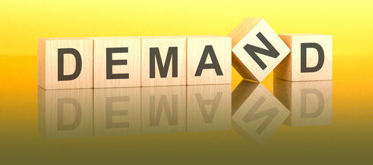 DEMAND text on wooden blocks on a yellow table. light background. stock market concept