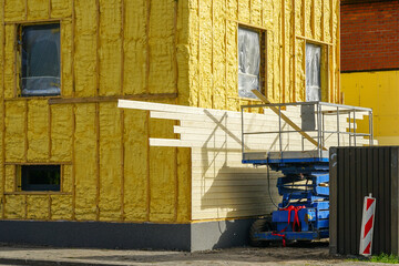 Facade siding works with wooden planks after facade spraying with thermal insulation foam