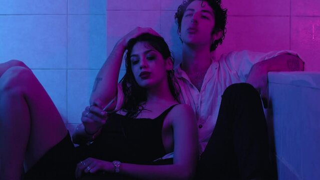 drugs, addiction - stoned young couple flirts in the bathroom passing a joint
