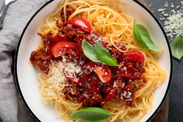 Pasta spaghetti bolognese with minced beef sauce, tomatoes, parmesan cheese and fresh basil in a plate. Italian food