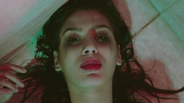 depression, apathy - motionless girl lying on the floor stares at the camera 
