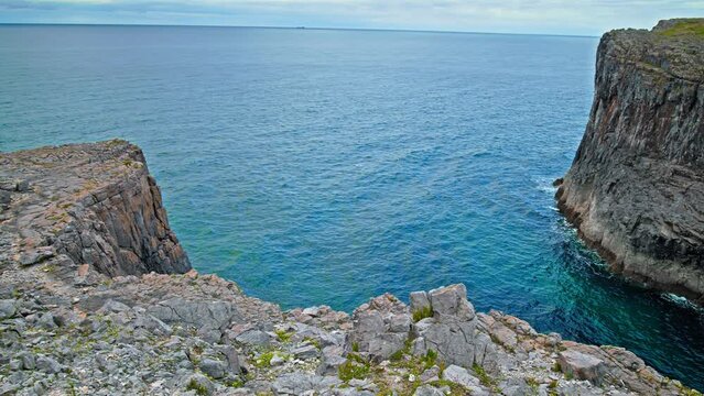Turquoise water by the two big cliffs in Pembrokeshire Coast National Park. Green Irish Sea and rocky formation in Wales.