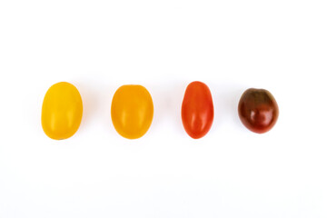 Different sorts of tomatoes isolated on white background.
Fresh, ripe type of small and round cocktail tomatoes, of red, yellow and orange color. Solanum lycopersicum var. cerasiforme. 