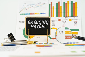 Against the background of business graphs, a board with the inscription - emerging market