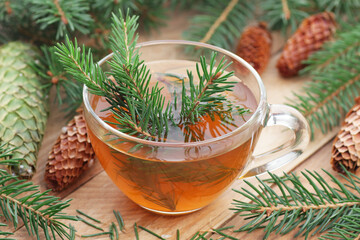 Fir tree essential oil or extract in glass bottle with  cones and wood spruce on wooden rustic...