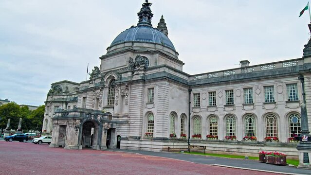 View of Cardiff City Hall municipal building with a clock tower and a Welsh dragon sculpture in Cardiff. The Edwardian baroque civic centre of local government in Wales. 