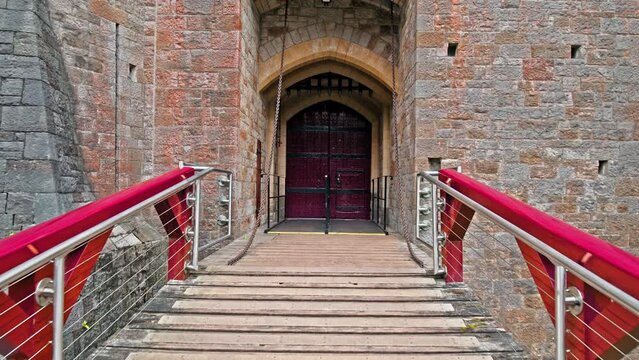 Tall large entrance gate of Red Castell Coch with great towers and conical roofs in Cardiff, Wales. Gothic-revival style with ancient beech woods in Wales.
