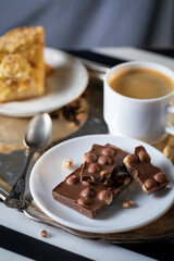Cup of coffee and chocolate with hazelnuts on the morning table