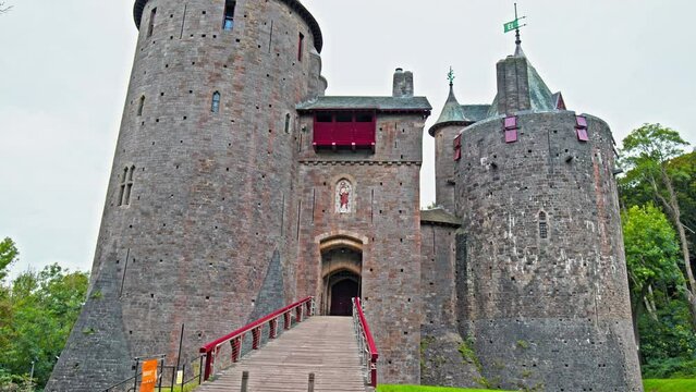 Red Castell Coch with great towers and conical roofs in Cardiff, Wales. Castle built in the gothic-revival style surrounded by ancient beech woods of Fforest Fawr like a vision from a fairy tale
