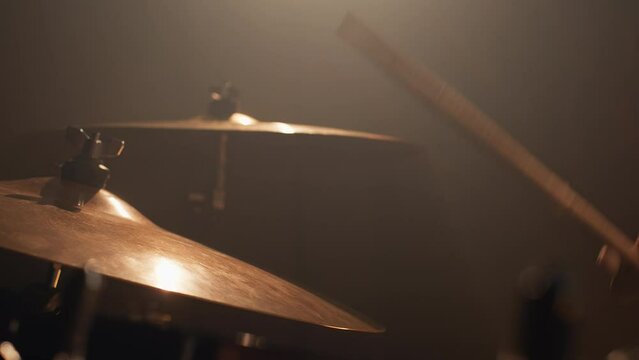 The drummer hits the drum cymbal with drumstick. Drummer plays the drums in the recording studio. Music band having rehearsal. Close-up