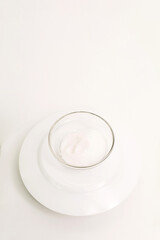 Table salt in a glass plate on a white background.
