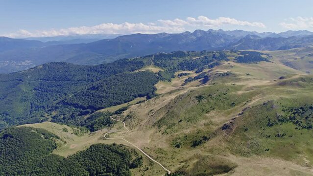 aerial shot above hills, hiking paths and mountains at pic de l'Ourtiset in the Pyrenees region France on a summer day