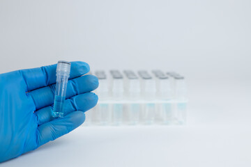 A laboratory medical worker demonstrates test tube for analysis. Test tubes in stand