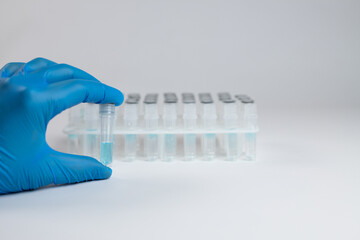 A laboratory medical worker demonstrates test tube for analysis. Test tubes in stand