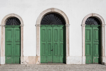 Old colonial facade with three green wooden doors. Santos city, Brazil