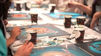 Kids coloring art class with paper cups and hand drawing.