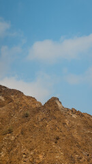 Fujairah mountains, extension of Omani Al Hajar mountain range. Cloudy winter day on empty street.