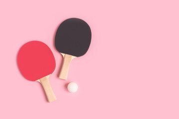 Tennis rackets and white ball on a pink pastel background. Place for text.