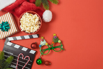Christmas movie night and party concept with  popcorn, Santa hat, decorations and movie clapper...
