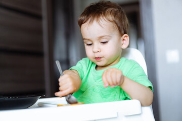 The Curious Toddler in the High Chair. A little boy that is sitting in a high chair