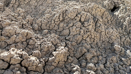 Dry, rocky terrain with huge cracks and splits in the ground due to heat in the Badlands on a hot afternoon. Close up shot.