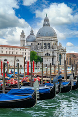Grand canal with gondola and Basilica di Santa Maria della Salute in Venice, Italy. Architecture and landmarks of Venice. Venice postcard