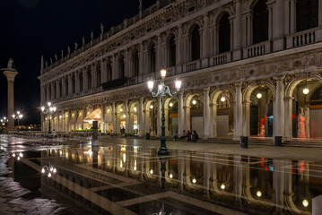 Fototapeta na wymiar Night view of piazza San Marco with tables of cafe in Venice, Italy. Architecture and landmark of Venice. Night cityscape of Venice.