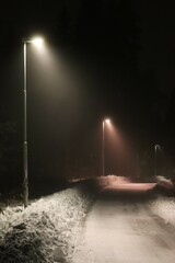 Night in fog one winter. Outdoor lighting in snowy weather.