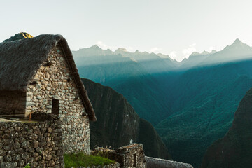 world heritage site Machu Picchu in Peru at sunrise with sunrays on the mountain