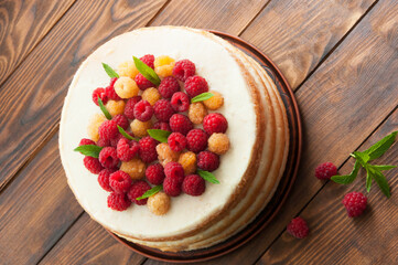 sponge cream cake with ripe red and yellow raspberries. fresh, colorful and delicious dessert with juicy raspberries and sweet whipped cream. The concept of home baking fruit