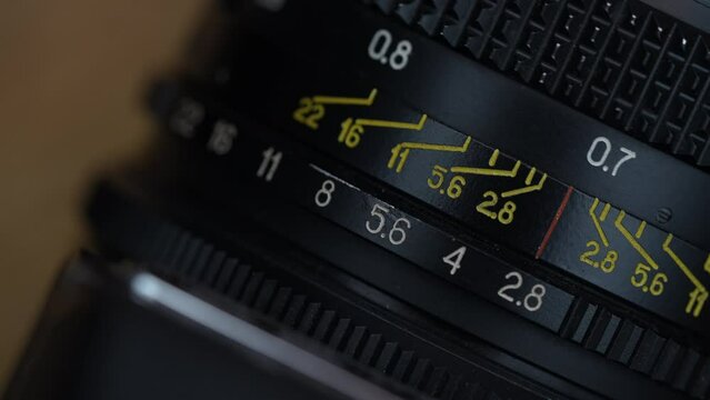 An old camera lens close up. The lens, focus and exposure controls of a simple classic 35mm film retro camera, macro