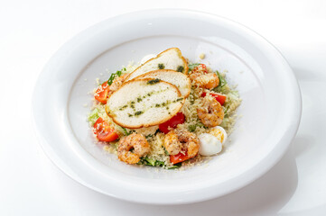 caesar salad with shrimp in a plate on a white background