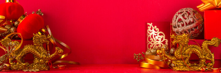 Chinese New Year 2024 greeting card. Bright red asian year of the dragon background with golden dragon figurine, Chinese lanterns, traditional jewelry, gifts, coins, cookies with wishes, copy space