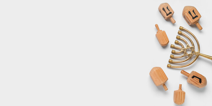 Dreidels and menorah on white background with space for text, top view. Hanukkah celebration