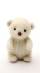 A small white bear sitting on a white surface