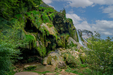 Baume-Les-Messieurs, France - 09 03 2021: View of the Tufs waterfall with low water flow. - obrazy, fototapety, plakaty