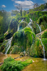 Baume-Les-Messieurs, France - 09 03 2021: View of the Tufs waterfall with low water flow. - obrazy, fototapety, plakaty