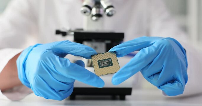 Engineer with microscope for repairing and soldering microcircuits of mobile phones and electronic devices